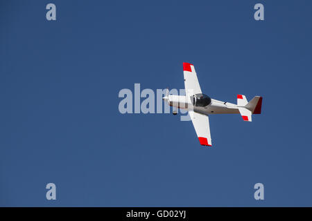 Draufsicht der kleinen weißen Flugzeug fliegen am strahlend blauen Himmel Stockfoto