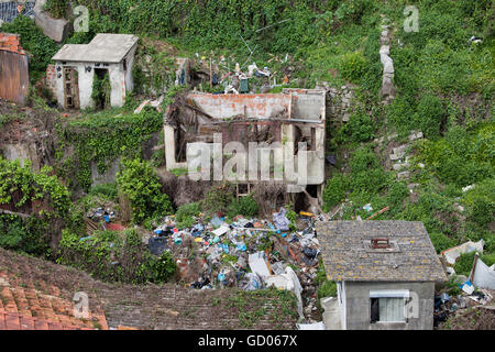 Ruinen von einem Hang Haus, Abandonded mit Müll und Kletterpflanzen Pflanzen am Hang um ihn herum Stockfoto