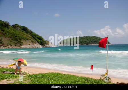 Reisende Reisen und entspannen am Nai Harn Strand in Phuket, Thailand, während rote Warnflaggen Strand wind und Welle der Wut-Show am Stockfoto