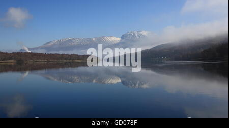 Ben Nevis spiegelt sich in Loch Eil an einem kalten, nebligen Morgen im März. Stockfoto