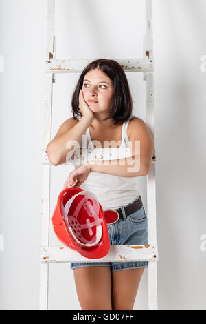 Frau mit Bau Bauarbeiterhelm auf hellem Hintergrund Stockfoto