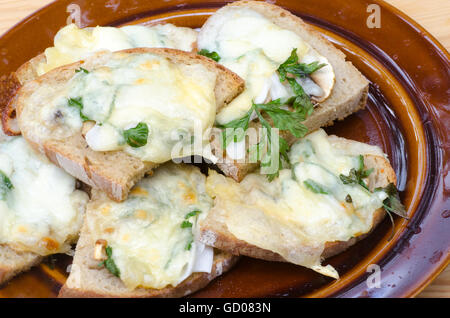 gegrilltes Brot mit geschmolzenem Käse und Petersilie Stockfoto