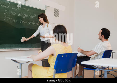 Lehrer steht an der Tafel und löschen waschen Tafel vor Klassenzimmer Stockfoto