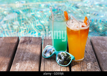 Cocktails mit Sonnenbrille neben dem Pool auf dem Hintergrund des Wassers Stockfoto