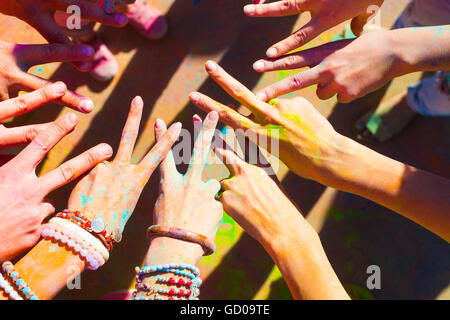 Freunde, die ihre Hände als Zeichen der Einheit und Teamarbeit zusammenzustellen. Holi Farben fest. Freundschaft-Konzept Stockfoto