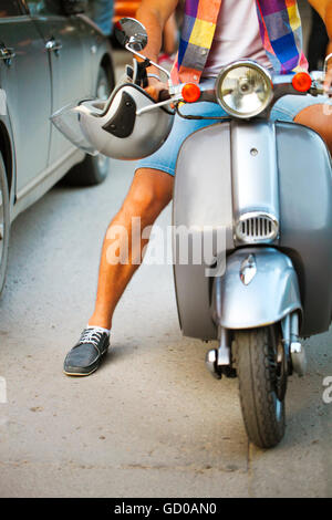 Junger Mann Reiten Roller entlang der Straße. Nahaufnahme Stockfoto