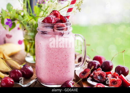 Frische hausgemachte gesunde Beeren-Smoothie im Einmachglas auf Fensterhintergrund Stockfoto