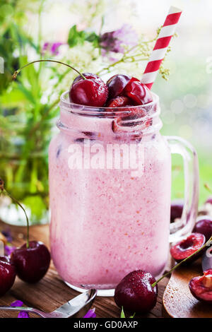 Frische hausgemachte gesunde Beeren-Smoothie im Einmachglas auf Fensterhintergrund Stockfoto