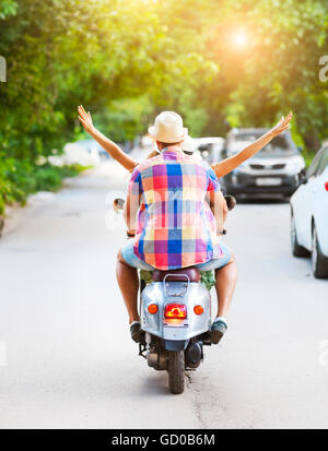 Glückliches junges Paar Oldtimer Motorroller auf der Straße tragen Hüte. Urlaub und Reisen-Konzept Stockfoto