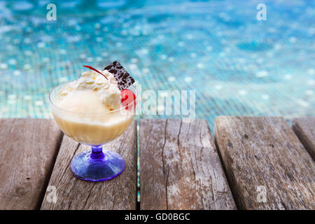 Mango-Eis mit Schokolade und Kirschen am Pool Stockfoto