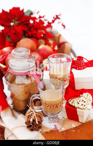 Weihnachten-Stillleben mit einem Weihnachtsschmuck, Cookies, Äpfel, Geschenke und heiße Schokolade eingebettet in frischem Schnee Stockfoto