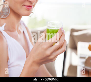 Frau mit Glas ein grüner Saft in der Hand Hand beim Frühstück am Morgen Stockfoto