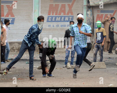 Srinagar, indische verabreicht Kaschmir. 10. Juli 2016. Kashmiri Demonstranten werfen Felsen auf (un gesehen) indische Polizei während einer Protestaktion gegen indische Kräfte eröffnet das Feuer auf Tausende von Demonstranten, mindestens fünfzehn Zivilisten töten und verwunden Kerben von anderen während einer Masse Beerdigung für einen getöteten Rebellen fighter.on July9 Tausende trotzte eine Ausgangssperre nach dem Tod von einem Top Rebel commander.clashes zwischen Kashmiri muslimische Demonstranten und Regierungstruppen nach der Tötung von militanten Oberbefehlshaber Burhan Muzaffar Wani am Ende 08 Juli. Bildnachweis: Sofi Suhail/Alamy Live-Nachrichten Stockfoto