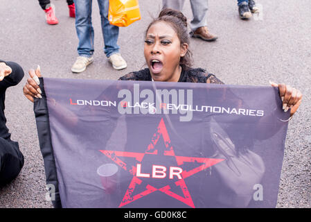 Brixton, London, UK. 9. Juli 2016. Demonstrant London Black revolutionäre sitzen auf der Straße zu unterstützen. Hunderte von schwarzen lebt Angelegenheit Anhänger marschierten auf der lokalen Polizeistation bevor ein Sit-in protestieren auf Brixton High Street, die Straßen Londons zum Stillstand gebracht. Der Marsch ist als Reaktion auf die tödlichen Schüsse von Philando Kastilien in Minnesota und Alton Sterling in Louisiana. Bildnachweis: Nicola Ferrari/Alamy Live-Nachrichten. Stockfoto