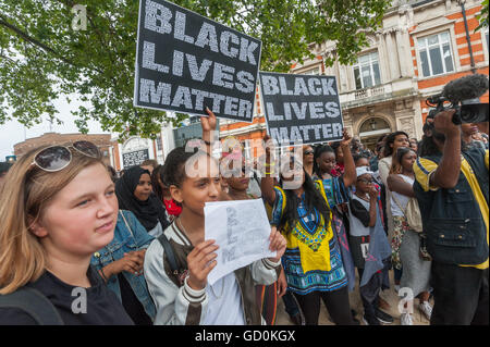 London, UK. 9. Juli 2016. Menschen halten Plakate mit der Meldung "Black lebt Materie" bei der Rallye in Brixton in Erinnerung an Alton Sterling und Philando Kastilien und zur Solidarität mit jenen von Polizeibrutalität, sowohl in den USA und hier im Vereinigten Königreich ermordet. Was hatte soll eine kurze Rallye vor einen Marsch vorbei Brixton Polizeistation und rund um den Bereich zeigte keine Zeichen als ich mit Lautsprecher nach Lautsprecher kommen, um den open Mike Windrush Platz verließ um ihre Gefühle auszudrücken und positive Maßnahmen für Gerechtigkeit fordern, zu beenden. Peter Marshall/Alamy Live-Nachrichten Stockfoto