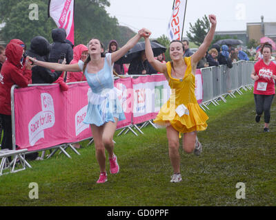 Portsmouth, Hampshire, UK. 10. Juli 2016. Zwei Frauen feiern, wie sie die Ziellinie des Rennens für das Leben. Das Rennen für das Leben ist ein Charity-Event, in dem Frauen eine 10 absolvieren, Km oder 5 Km laufen zugunsten der Krebs-Forschung. Bildnachweis: Simon Evans/Alamy Live News Stockfoto