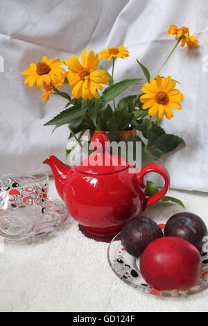 roter Ton Teekanne, Glaspokale, Reife Früchte auf Platte Blumenstrauß frische gelbe Blüte, die alle zum Frühstück vorbereiten Stockfoto