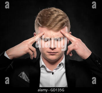 Junger Mann hielt seinen Kopf Kopfschmerzen fühlen oder denken intensiv nach. Stockfoto