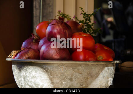 Eine alte Alu-Schüssel halten rot oder spanische Zwiebeln, Tomaten und Thymian Stockfoto