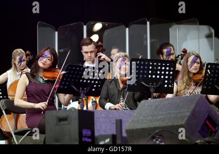 Mitglieder des Orchesters Rogue mit Gesichtern bemalt wie Ziggy Stardust führen ein David Bowie Tribute setzen auf der Hauptbühne am dritten Tag des T im Park, das jährliche Musikfestival Schloss Strathallan, Perthshire. Stockfoto