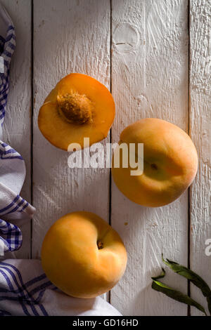 Percoche (gelbe italienische Pfirsiche) auf weißem Holz Stockfoto