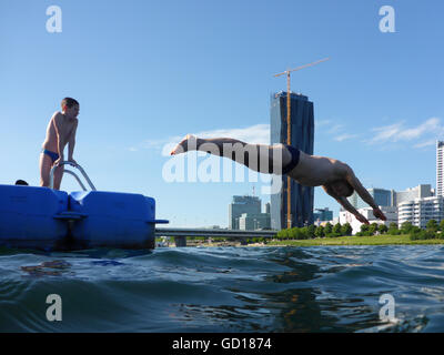 Wien, Wien: Vater und Sohn / Mann und der junge Baden in der neuen Donau vor der DC Tower und der Donau City, Österreich, Wien, 22. Stockfoto