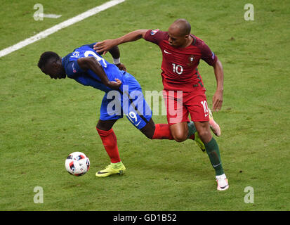 Frankreichs Bacary Sagna (links) und Portugals Joao Mario Kampf um den Ball im Finale UEFA Euro 2016 im Stade de France, Paris. Stockfoto