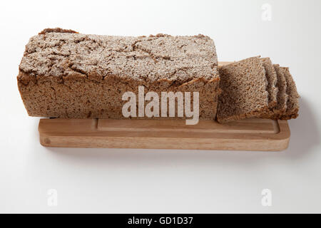 Laib Vollkornbrot und Brotscheiben auf einem Holzbrett Stockfoto