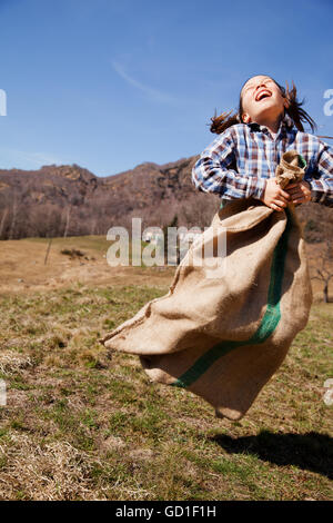 Kleines Mädchen springt in meschotschek Kartoffeln, sie ist glücklich Stockfoto