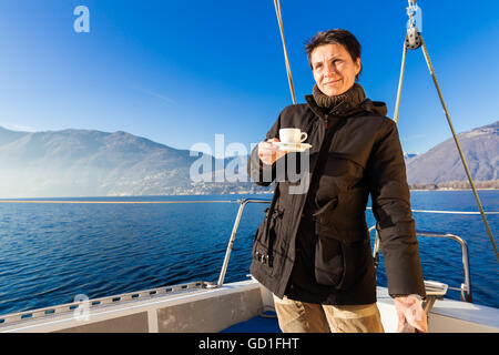 Frau macht eine Kaffeepause an Bord sein Segelboot Stockfoto