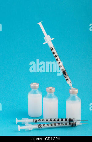 Insulin-Flaschen (s) und Spritze auf blauem Grund Stockfoto