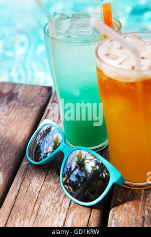 Cocktails mit Sonnenbrille neben dem Pool auf dem Hintergrund des Wassers Stockfoto