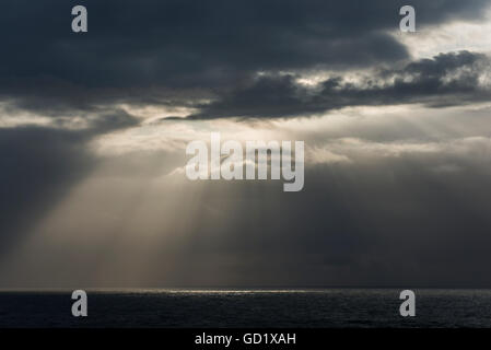 Sonnenlicht bricht durch die Wolken über dem Meer an der Küste Oregons; Cannon Beach, Oregon, Vereinigte Staaten von Amerika Stockfoto