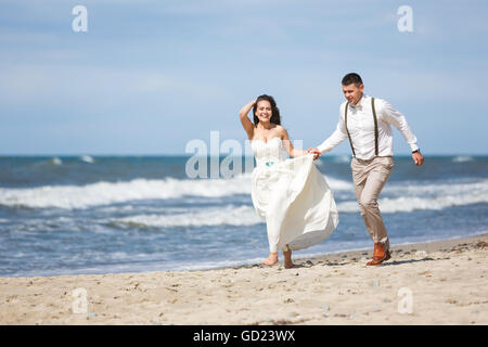 Fröhliche Hochzeitspaar am Strand im Sommer Stockfoto