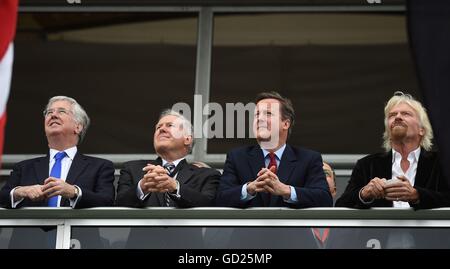 Premierminister David Cameron (zweiter von rechts) und Sir Richard Branson (rechts) mit Defence Secretary Michael Fallon (links) bei der Farnborough International Airshow in Hampshire. Stockfoto