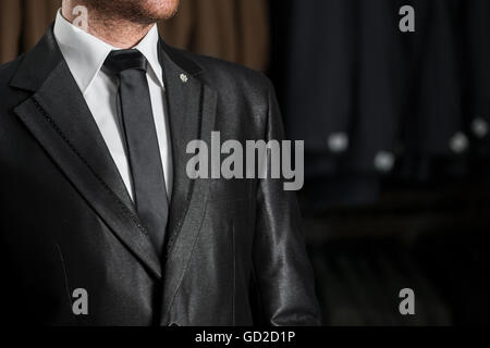 Junger Mann in einem schwarzen Hochzeitsanzug und Krawatte über weißes Hemd Stockfoto