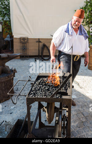 Friedberg, Deutschland - 9. Juli 2016: Ein Mann in Tracht gekleidet als Schmied in der traditionellen Weise des th arbeitet Stockfoto