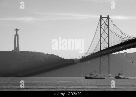 Schleppboote Segeln unter der Hängebrücke Ponte 25 de Abril & Christus-Statue. Lissabon Stockfoto