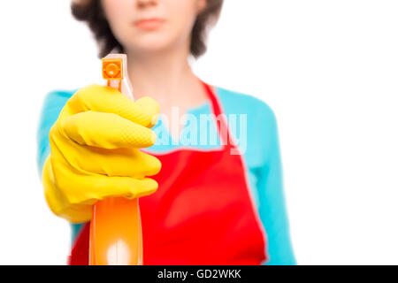 weibliche Hand in gelben Handschuh leitet das Reinigungsspray an der Kamera auf weißem Hintergrund Stockfoto