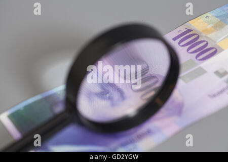 Schweizer 1000 Franken Banknoten unter Lupe auf grauem Hintergrund Stockfoto