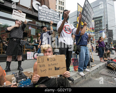 Inmitten religiöser Demonstranten am Witchsfest in New York hält ein Mann eine lustige Schild mit der Aufschrift, dass er jemand unterstützen würde, die ihm Zigaretten kaufen würde Stockfoto