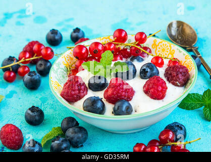 Gesunde Joghurt mit Himbeeren, Heidelbeeren und roten Johannisbeeren Stockfoto