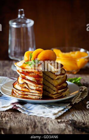 Stapel von hausgemachte Pfannkuchen mit pochierte Pfirsiche Stockfoto