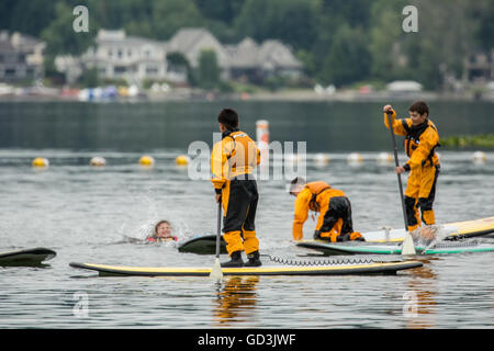 Junges Mädchen gefallen aus ihrem Paddleboard während einer Paddling-Klasse im Lake Sammamish State Park, Issaquah, Washington, USA Stockfoto