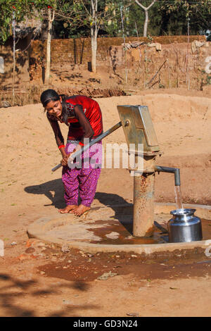 Stamm Mädchen das Pumpen von Wasser aus der Handpumpe, Bastar, Chhattisgarh, Indien, Asien Stockfoto