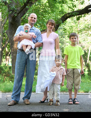 glückliche Familienbild auf outdoor, Gruppe von fünf Menschen posieren im Stadtpark, Sommersaison, Kind und Elternteil Stockfoto