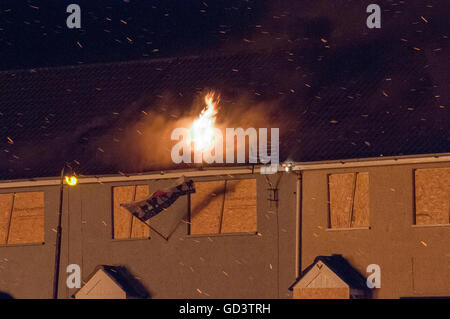 Belfast, Nordirland. 11. Juli 2016 - Funken von der traditionellen "11. Nacht" Lagerfeuer auf das Dach eines Hauses, angezündet während andere mit der Hitze zu Rauchen beginnen. Bildnachweis: Stephen Barnes/Alamy Live-Nachrichten Stockfoto