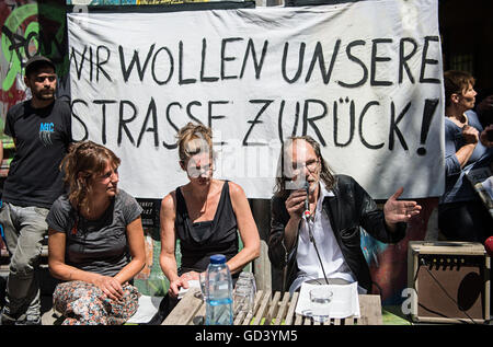 "Wir Wollen unsere Straße Zurück!" (lit. wir wollen, dass unsere Straße zurück) steht auf einem Banner hinter Bewohner der Verbürgerlichung Strasse, während einer Pressekonferenz in Friedrichshain in Berlin, Deutschland, 12. Juli 2016. Sie diskutieren Anregungen wie man die Situation rund um das Haus Nr. 94, entschärfen wo Autonomisten und Polizei wiederholt zusammengestoßen haben. FOTO: WOLFRAM KASTL/DPA Stockfoto