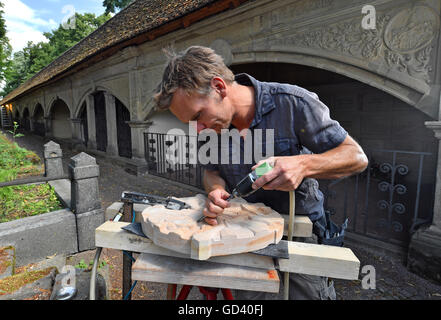 Bildhauer Martin Roedel arbeiten auf ein Sandsteinrelief vor der Arcade-Bögen am Stadtgottesacker in Halle/Saale, Deutschland, 12. Juli 2016. Die Restaurierung eines der schönsten Friedhöfe in Deutschland konzentriert sich meist auf Relief arbeiten. Die historisch bedeutsame Anlage wurde errichtet 1557 folgt den Friedhof Camposanto in Pisa, Italien. Foto: HENDRIK SCHMIDT/dpa Stockfoto