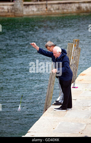 Ältere Männer besuchen Sie den beliebten Küstenort Looe, Cornwall Fischerei mit einer Hookline und sinker für Krabben oder Krabben, wie die Einheimischen es nennen, Cornwall, England, Großbritannien Stockfoto